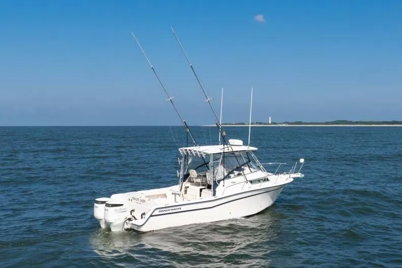 Slide: The Image of 1997 Grady-White Marlin 300 boat on open water with fishing rods and clear sky. - 27