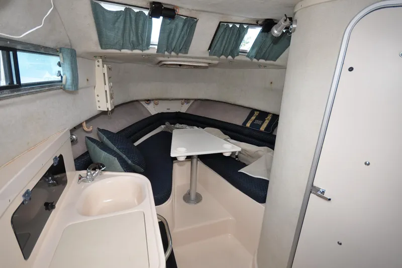 Slide: The Image of 1997 Grady-White Marlin 300 cabin interior with seating, table, and sink. - 6