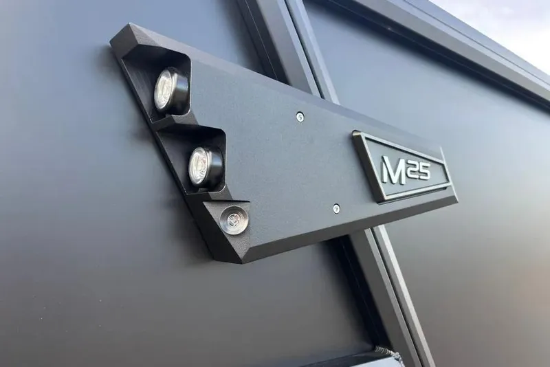 Slide: The Image of Close-up of 2026 Alera M25L vehicle badge and lights on a sleek black surface. - 9