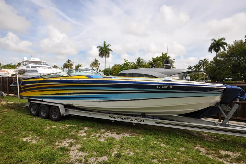 Slide: The Image of 2006 Formula 382 FASTech speedboat on trailer, vibrant stripes, parked outdoors. - 32