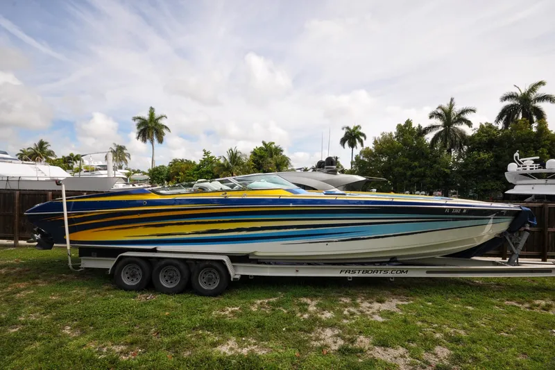 Slide: The Image of 2006 Formula 382 FASTech speedboat with vibrant stripes on a trailer, surrounded by palm trees. - 34