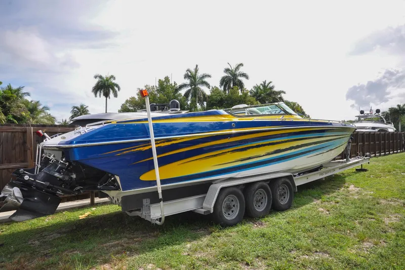 Slide: The Image of 2006 Formula 382 FASTech speedboat on trailer, vibrant blue and yellow design, parked outdoors. - 35