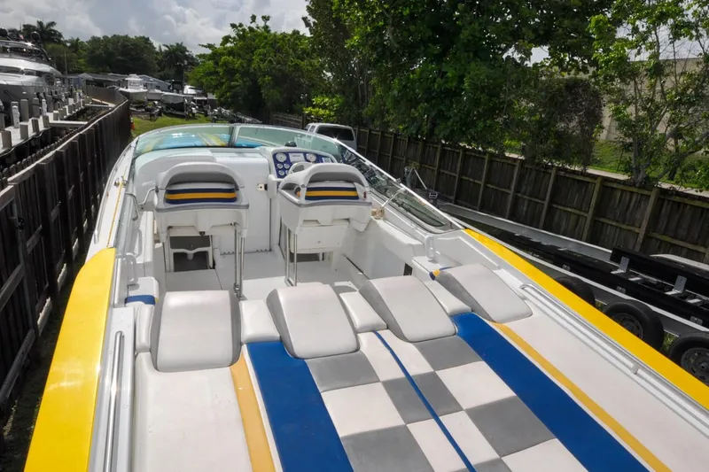 Slide: The Image of 2006 Formula 382 FASTech speedboat with vibrant yellow and blue interior, docked outdoors. - 9