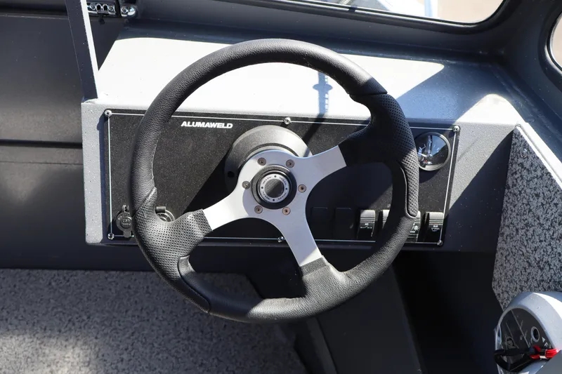 Slide: The Image of Steering wheel of 2026 Alumaweld Talon 18 boat, featuring modern dashboard controls. - 16