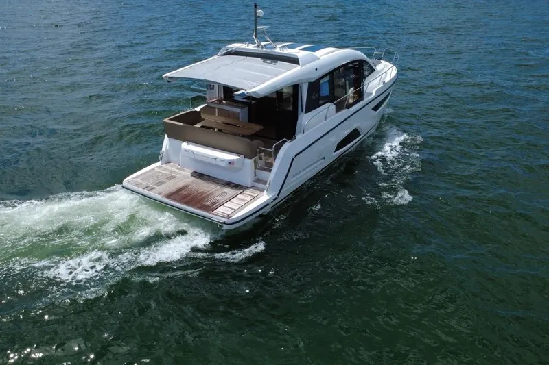 Slide: The Image of 2022 Sealine C430 yacht cruising on open water, showcasing sleek design and spacious deck. - 12