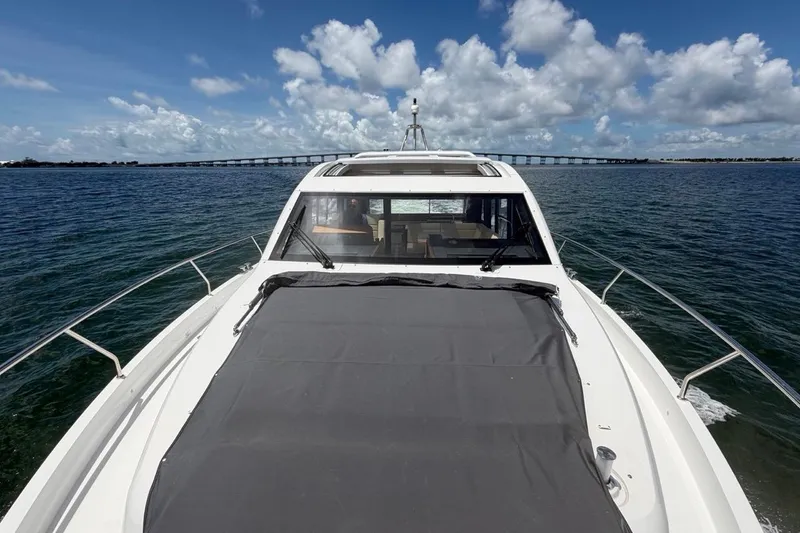 Slide: The Image of 2022 Sealine C430 yacht cruising on open water under a blue sky. - 14