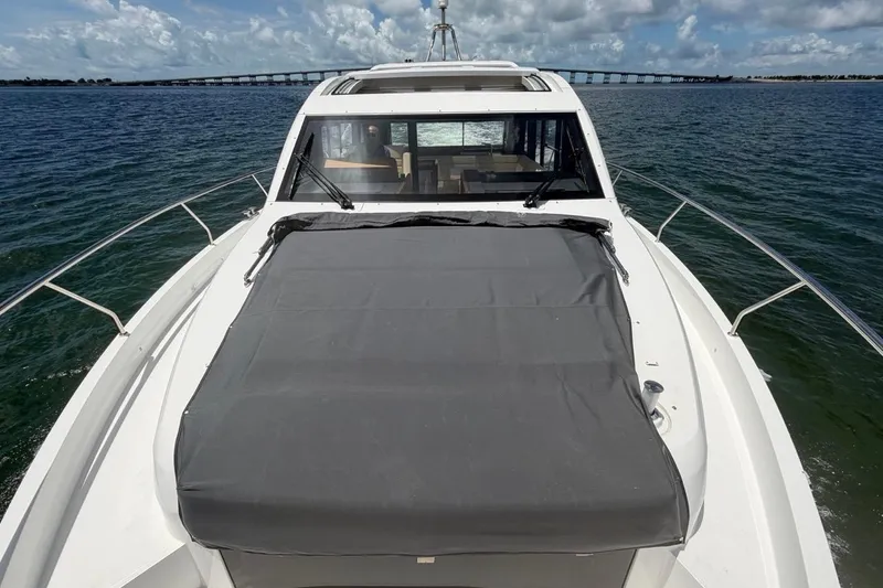 Slide: The Image of 2022 Sealine C430 yacht cruising on open water with bridge in background. - 15