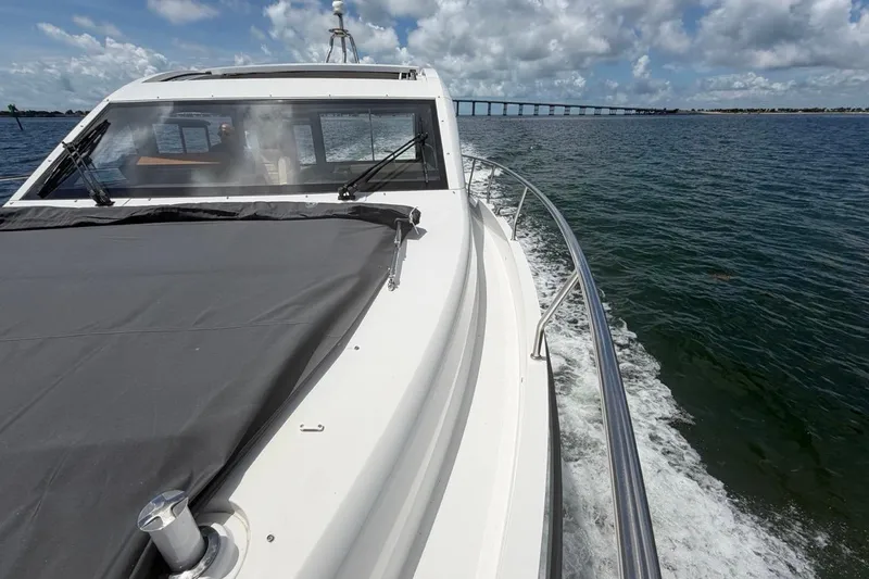 Slide: The Image of Sealine C430 yacht cruising on open water, 2022 model, with bridge in background. - 16