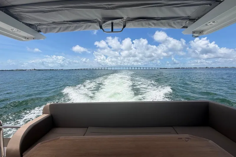 Slide: The Image of Sealine C430 yacht cruising on open water, leaving a wake under a clear blue sky. - 28