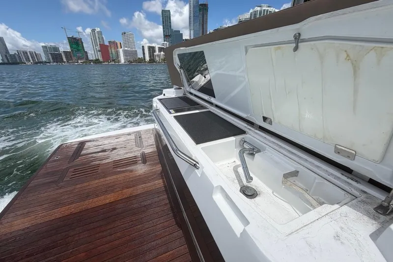 Slide: The Image of 2022 Sealine C430 yacht with open deck storage, city skyline in background. - 31