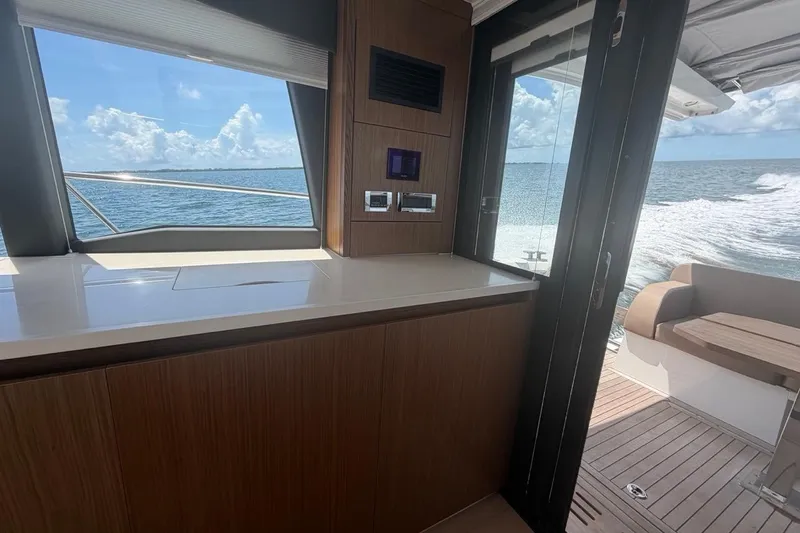 Slide: The Image of Interior view of 2022 Sealine C430 yacht with ocean backdrop and sleek wooden finishes. - 46