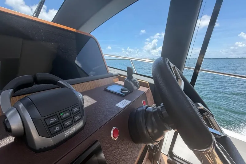 Slide: The Image of Helm of 2022 Sealine C430 yacht with steering wheel and controls, overlooking ocean. - 59