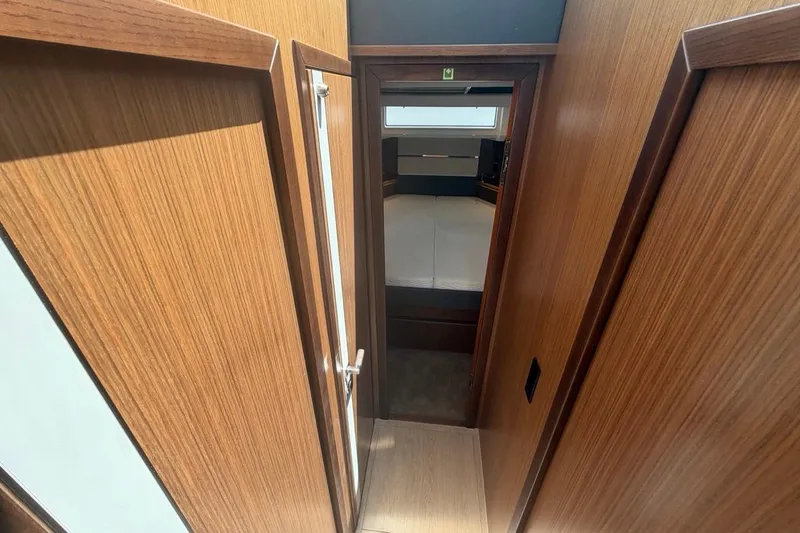 Slide: The Image of Interior view of 2022 Sealine C430 yacht, featuring wooden paneling and a cozy cabin entrance. - 65