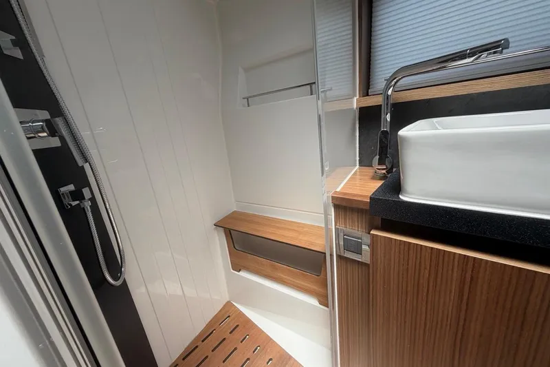 Slide: The Image of Modern bathroom interior of 2022 Sealine C430 yacht, featuring sleek wood and chrome finishes. - 73