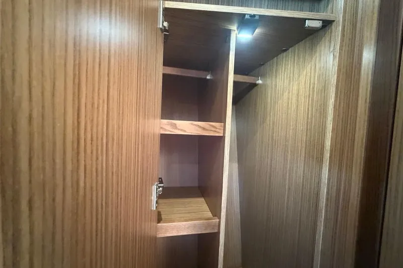 Slide: The Image of Wooden cabinet interior with shelves in a 2022 Sealine C430 yacht. - 85