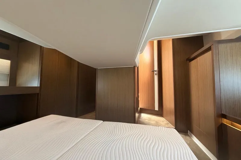 Slide: The Image of Interior cabin of 2022 Sealine C430 yacht with modern wood paneling and cozy bedding. - 88