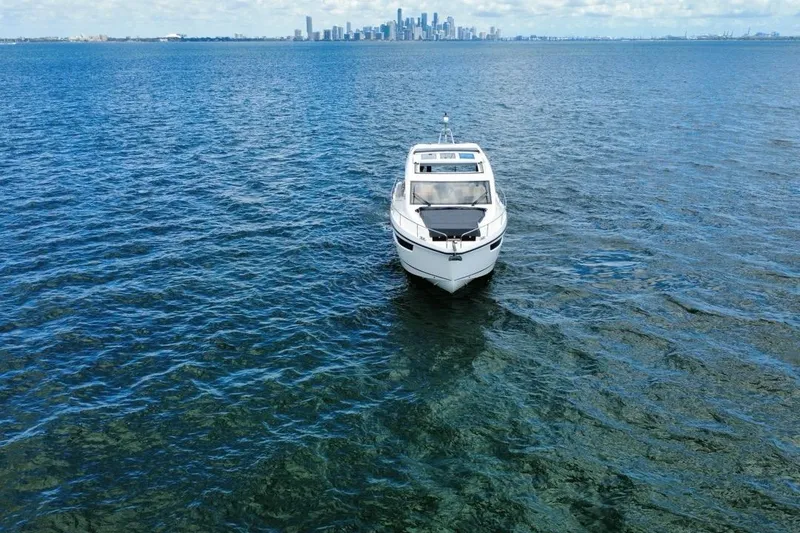 Slide: The Image of 2022 Sealine C430 yacht on open water with city skyline in background. - 9