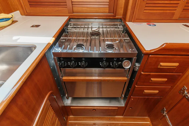 Slide: The Image of Hinckley Sou'wester 52 yacht kitchen with stove and wooden cabinetry, 1998 model. - 49