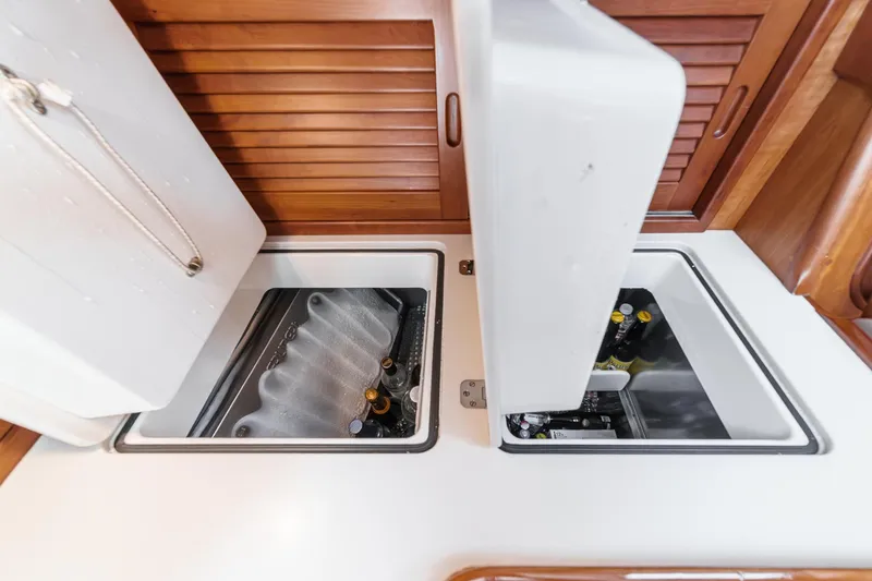 Slide: The Image of Hinckley Sou'wester 52 yacht interior with open storage compartments, showcasing beverages. - 50