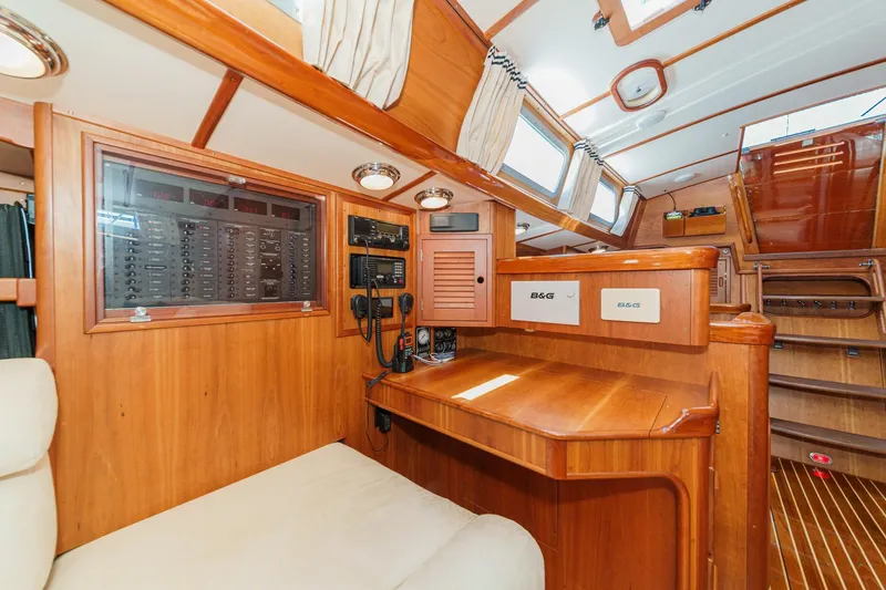 Slide: The Image of Interior of 1998 Hinckley Sou'wester 52 yacht with navigation station and wooden finish. - 60