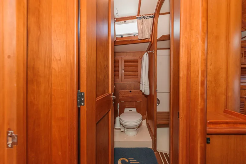 Slide: The Image of Hinckley Sou'wester 52 yacht bathroom with wooden interior, featuring a toilet and towel rack. - 68