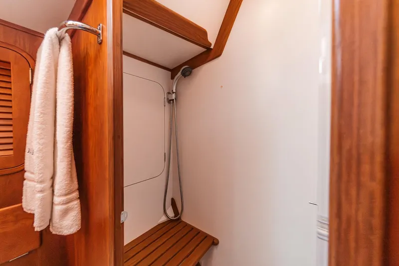 Slide: The Image of Shower area in 1998 Hinckley Sou'wester 52 yacht with wooden accents and towel rack. - 70