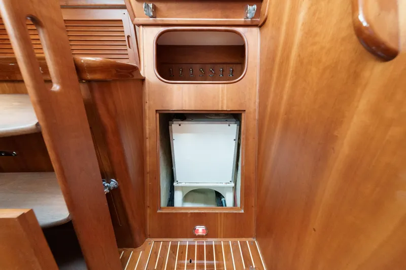 Slide: The Image of Interior of 1998 Hinckley Sou'wester 52 yacht with wooden cabinetry and storage compartment. - 76