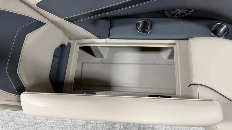 Slide: The Image of An open storage compartment in a boat with beige upholstery and cup holders. - 26