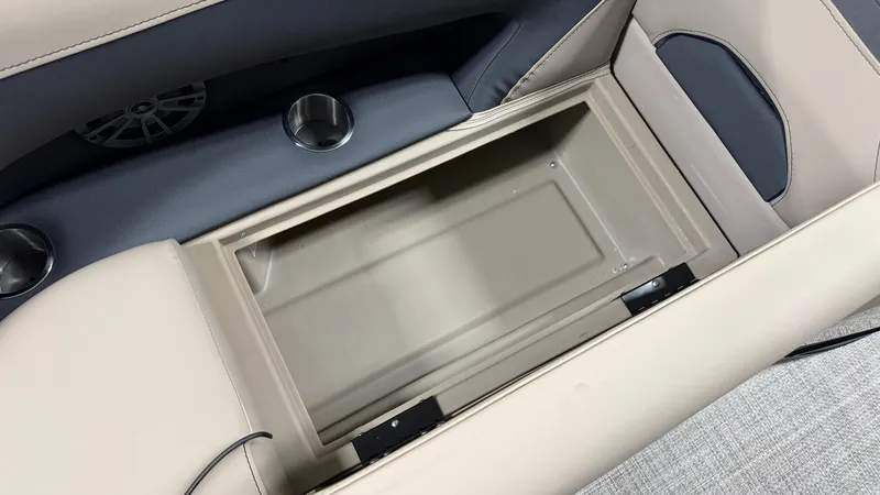 Slide: The Image of An open storage compartment on a Barletta ARIA22UC boat, surrounded by cushioned seats and cup holders. - 18