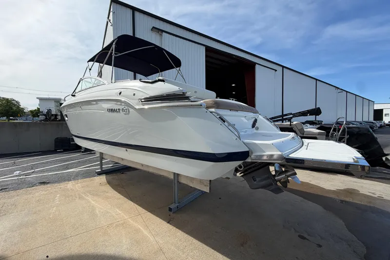 Slide: The Image of 2013 Cobalt 273 boat with canopy, displayed outside a warehouse. - 1