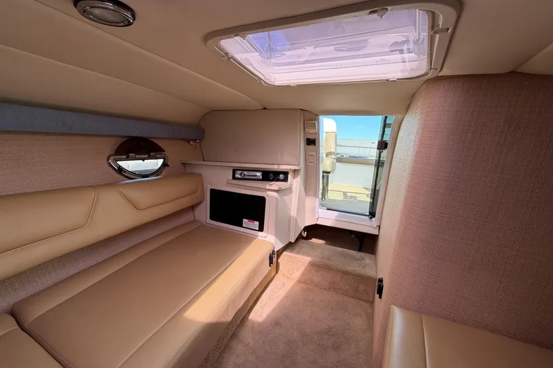 Slide: The Image of Interior of a 2013 Cobalt 273 boat cabin with beige seating and skylight. - 13