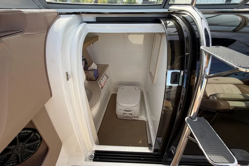 Slide: The Image of Interior of 2013 Cobalt 273 boat featuring compact bathroom with toilet and sink. - 15