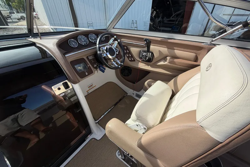 Slide: The Image of Interior of a 2013 Cobalt 273 boat featuring a sleek steering wheel and comfortable seating. - 16