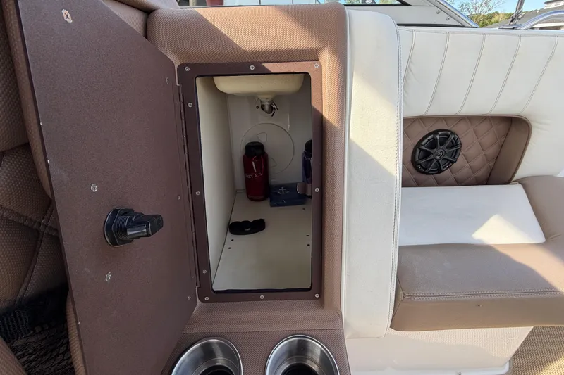 Slide: The Image of Interior storage compartment of a 2013 Cobalt 273 boat with cup holders and speaker. - 9