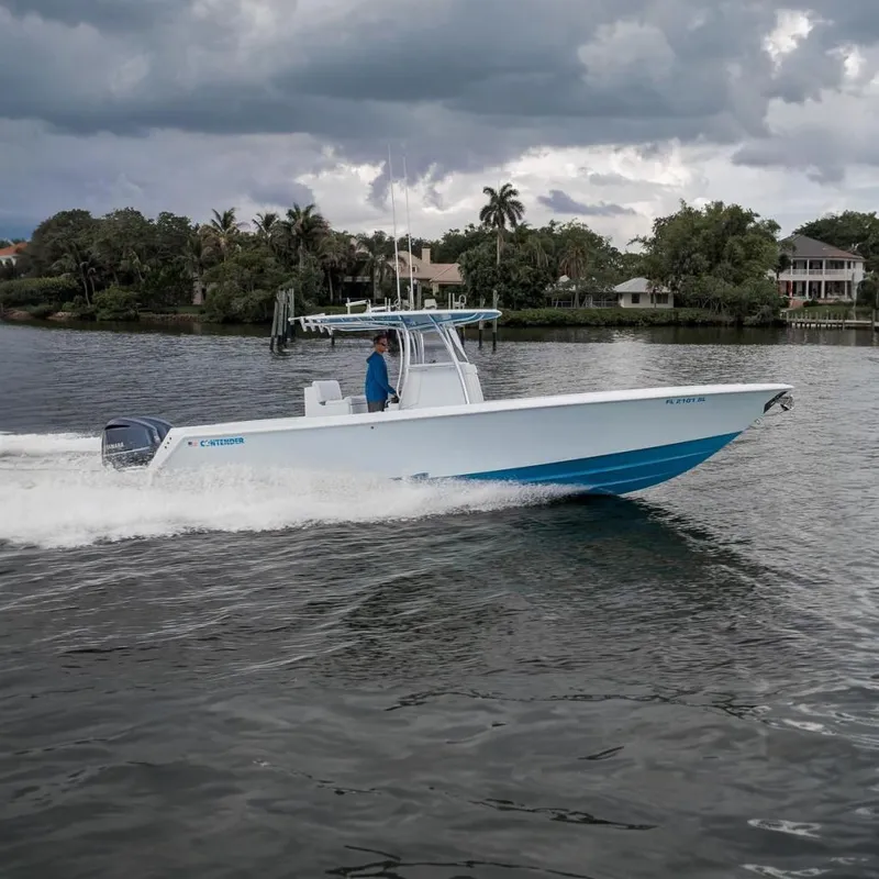 The Image of 2019 Contender 32 ST boat cruising on calm water under cloudy skies. - 0