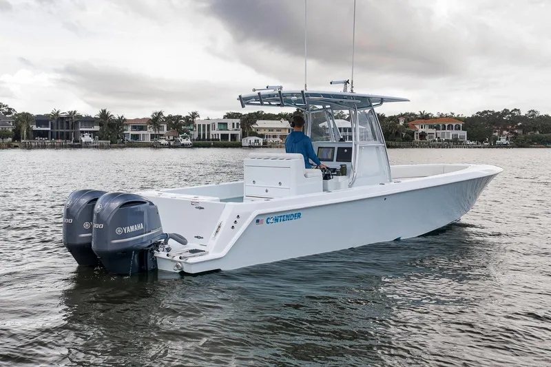 Slide: The Image of 2019 Contender 32 ST boat with dual Yamaha engines on a calm waterway. - 10
