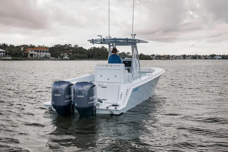 Slide: The Image of 2019 Contender 32 ST boat with dual Yamaha 300 engines on a calm waterway. - 11