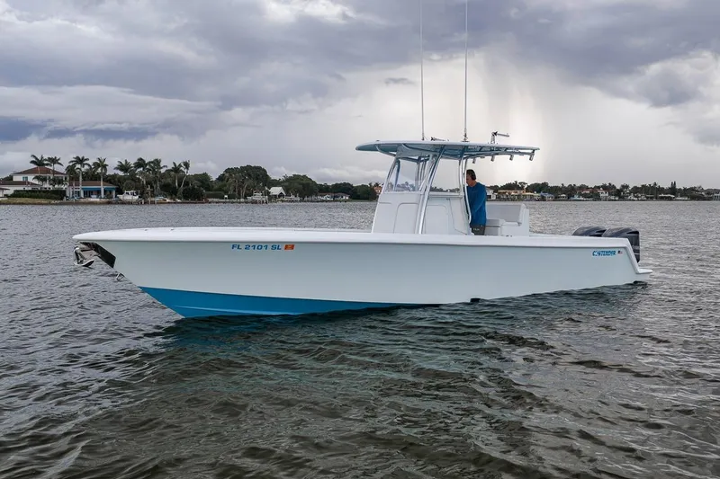 Slide: The Image of 2019 Contender 32 ST boat on water, overcast sky, coastal background. - 12