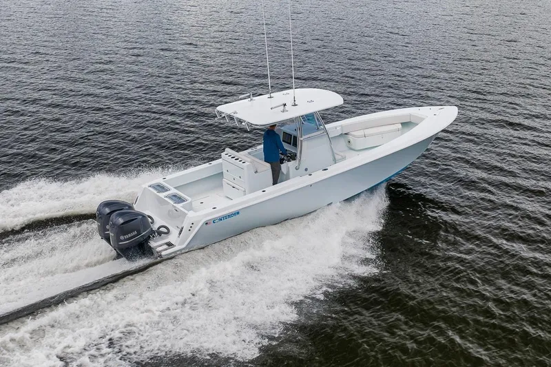 Slide: The Image of 2019 Contender 32 ST boat cruising on open water with dual Yamaha engines. - 17