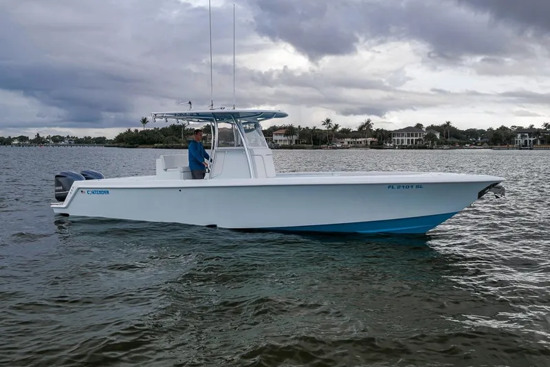 Slide: The Image of 2019 Contender 32 ST boat on water, overcast sky, coastal background. - 2
