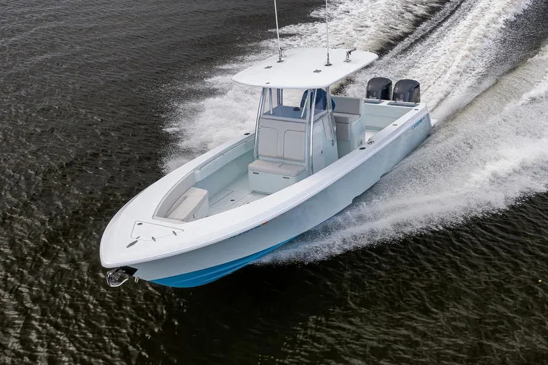 Slide: The Image of 2019 Contender 32 ST boat cruising on water, showcasing sleek design and powerful engines. - 23