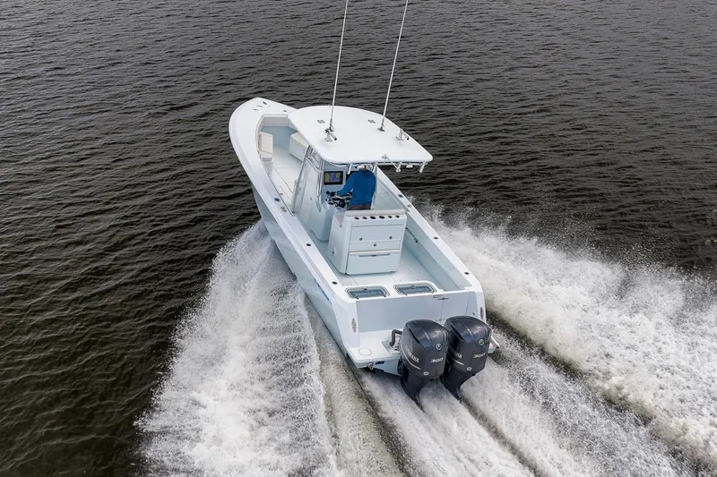 Slide: The Image of 2019 Contender 32 ST boat cruising on open water with dual engines. - 26