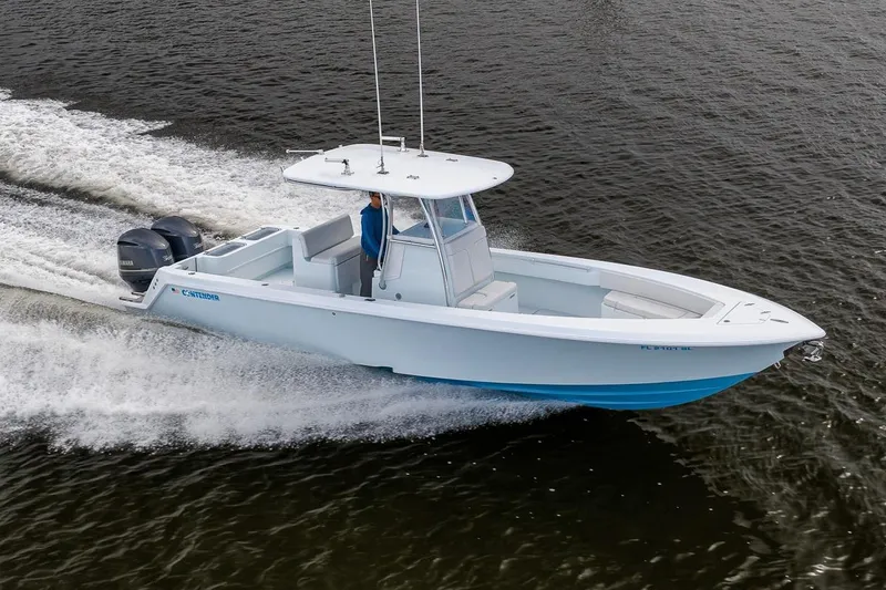 Slide: The Image of 2019 Contender 32 ST boat cruising on open water, featuring dual outboard engines. - 37