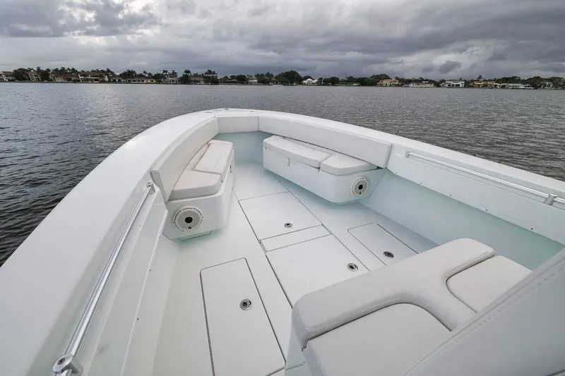 Slide: The Image of 2019 Contender 32 ST boat interior with cushioned seating on a calm lake. - 46