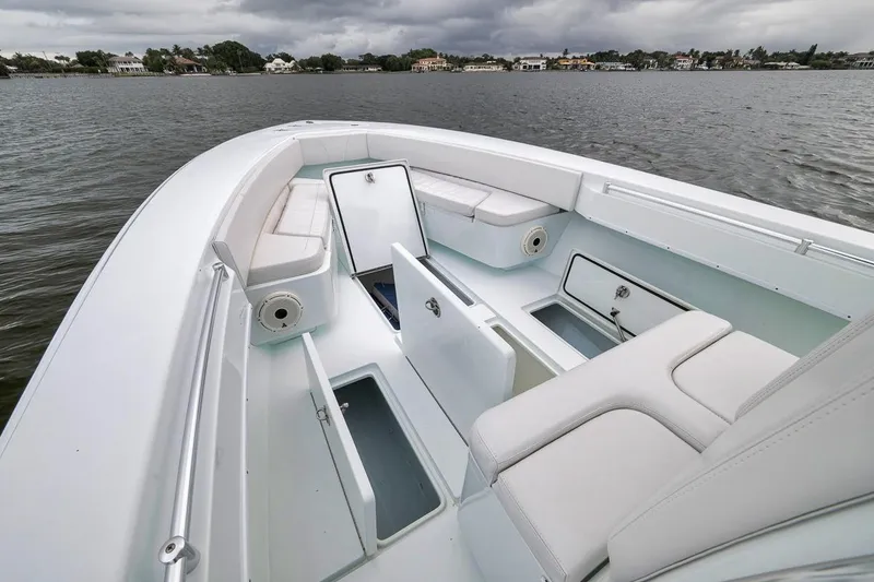 Slide: The Image of 2019 Contender 32 ST boat interior with open storage compartments on a calm lake. - 49
