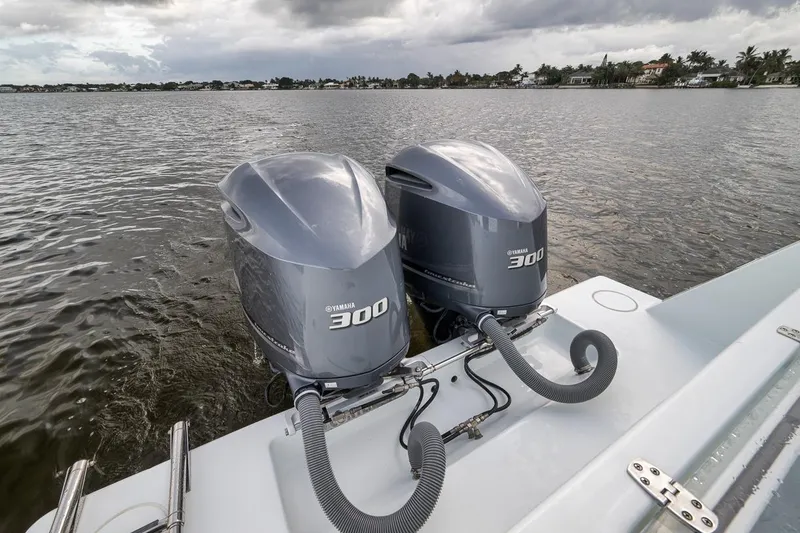 Slide: The Image of Twin Yamaha 300 engines on a 2019 Contender 32 ST boat, on a calm waterway. - 54