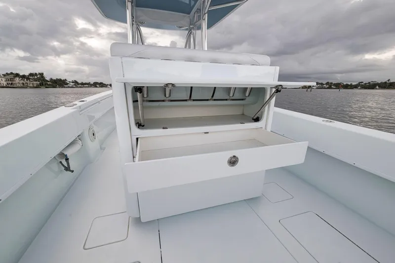 Slide: The Image of 2019 Contender 32 ST boat with open storage compartment on deck, under cloudy sky. - 60
