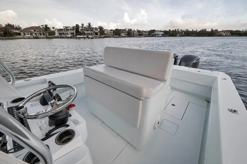 Slide: The Image of 2019 Contender 32 ST boat interior with steering wheel and seating, overlooking waterfront homes. - 65