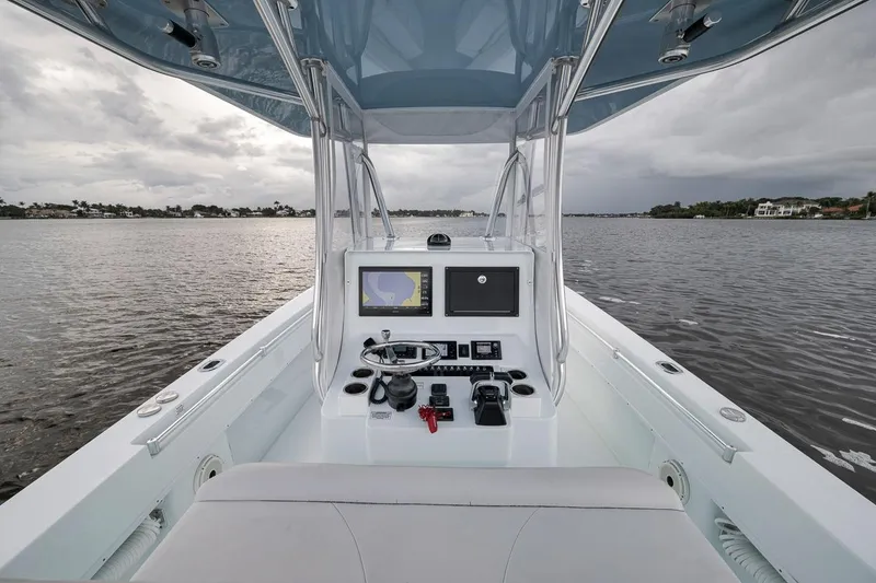 Slide: The Image of 2019 Contender 32 ST boat console with navigation screen on calm waters. - 66