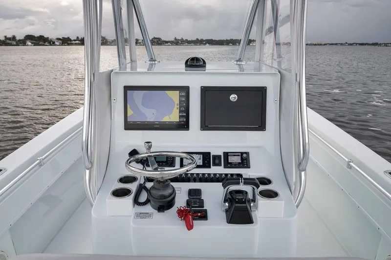 Slide: The Image of 2019 Contender 32 ST boat console with navigation screen and steering wheel on open water. - 67